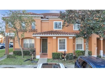 Attractive two-story townhome with dark brown front door and landscaping at 7606 Acklins Rd, Kissimmee, FL 34747