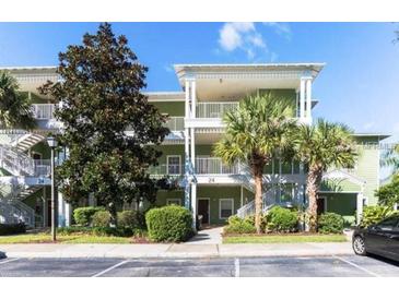 Two-story building with green exterior, balconies, and palm trees at 210 Watling Way # 24-210, Davenport, FL 33897
