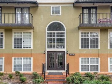 Condo building exterior featuring a well-maintained facade and attractive landscaping at 3936 Versailles Dr # 3936B, Orlando, FL 32808