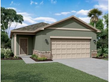 One-story house with green exterior, two-car garage, and landscaping at 2080 Hemingway Cir, Groveland, FL 34736