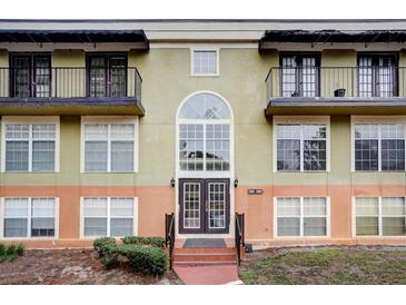 Building exterior featuring a classic design, double door entry, and balconies at 3954 Versailles Dr # 3954B, Orlando, FL 32808