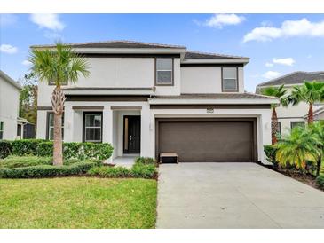 Two-story home with a modern design, two-car garage, and landscaped lawn at 4571 Cabello Loop, Kissimmee, FL 34746