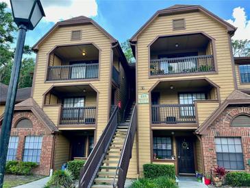 Two-story building with brick and wood siding, featuring a staircase and balconies at 485 Forestway Cir # 202, Altamonte Springs, FL 32701