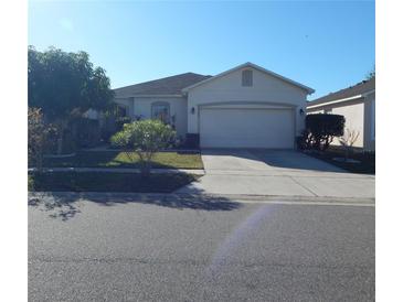 Single-story home with attached garage and landscaped lawn at 7539 Bear Claw Run, Orlando, FL 32825