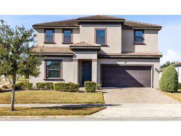 Two-story house with brown roof, two-car garage, and landscaped lawn at 181 Brookes Pl, Haines City, FL 33844