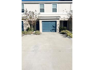 Two-story townhome with a teal garage door and landscaping at 2906 Fieldwood Cir, St Cloud, FL 34772