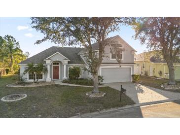 Two-story house with gray siding, red door, and attached garage at 117 Blue Heron Ct, Davenport, FL 33837