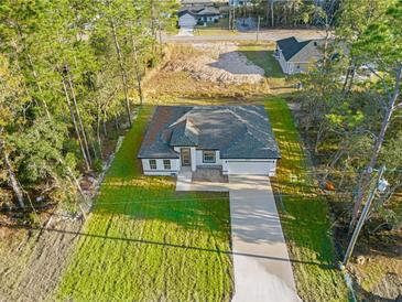 New construction home with driveway and landscaped yard, aerial view at 6770 Sw 149Th Lane Rd, Ocala, FL 34473