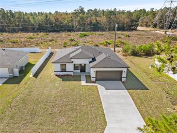 New construction home with driveway and grassy yard, aerial view at 16730 Sw 50Th Cir, Ocala, FL 34473