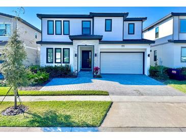 Modern two-story home with a paved driveway and landscaped front yard at 6234 Sand Skipper Rd, Orlando, FL 32821