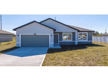 Newly constructed home with gray exterior and a two-car garage at 904 Desmoines Way, Poinciana, FL 34759