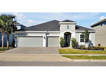 Two-story house with gray siding, two-car garage, and landscaped front yard at 3359 Hanging Tide St, Winter Garden, FL 34787