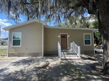 Tan house with brown door, white steps, and landscaping at 1170 S Central Ave, Apopka, FL 32703