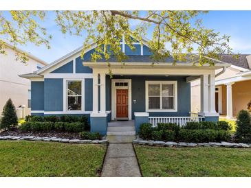 Charming craftsman style home with a blue exterior and landscaped front yard at 14272 Southern Red Maple Dr, Orlando, FL 32828