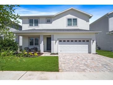 Two-story house with white exterior, gray roof, and a white garage door at 159 Golden Noble St, Kissimmee, FL 34747