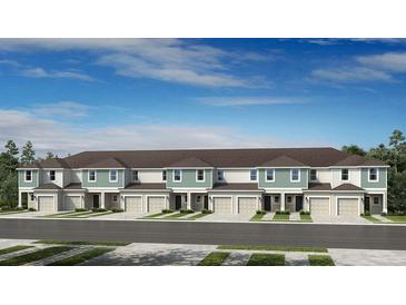 Front view of townhouses with attached garages and neutral color palettes at 219 River Front Way, Edgewater, FL 32141