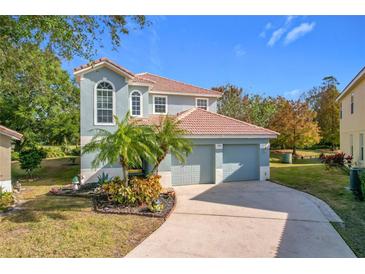 Two-story house with two-car garage, landscaping, and a palm tree at 944 Torrey Pine Dr, Winter Springs, FL 32708