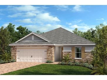 Attractive single-story home with stone accents, a two-car garage, and a landscaped front yard at 638 Meadows Edge Pl, Lake Wales, FL 33859