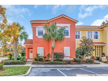 Two-story coral home with palm trees and landscaped yard at 4756 Ormond Beach Way, Kissimmee, FL 34746