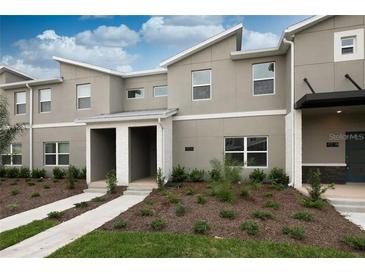 Modern two-story townhome with gray exterior and white accents at 4241 Paragraph Dr, Kissimmee, FL 34746