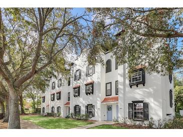 Charming white townhomes with black shutters and red tile roofs nestled among mature trees at 234 N Glenwood Ave # 4, Orlando, FL 32803