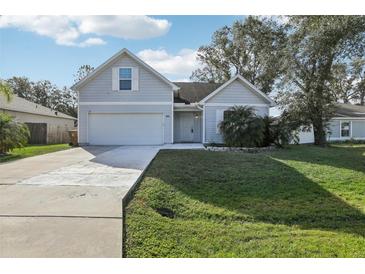 Charming two-story home with a paved driveway, landscaped yard, and attached garage at 1004 Puget Ln, Kissimmee, FL 34759