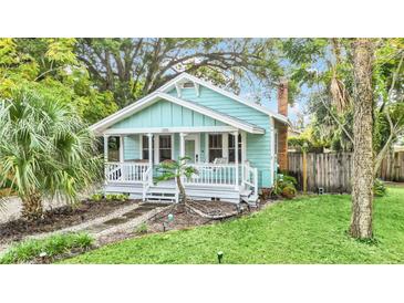 Charming light blue house with a white porch and landscaped yard at 1550 Indiana Ave, Winter Park, FL 32789