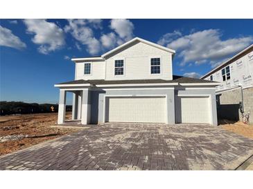 New two-story home with a two-car garage and a paved driveway at 2075 Heart Lake Dr, Groveland, FL 34736