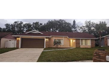 Brick ranch house with brown garage door and landscaped lawn at 1859 Lake Hill Cir, Orlando, FL 32818