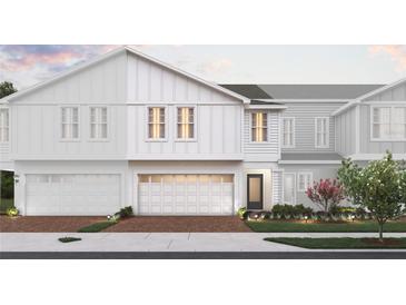 Modern two-story home with white siding, two-car garage, and landscaped yard at 160 Glass Onion Dr, Groveland, FL 34737