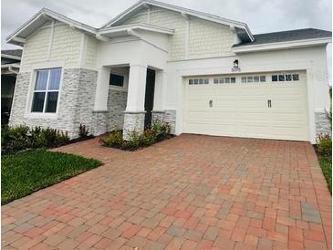 Two-story home with stone accents and a brick driveway at 5015 Dancy Ln, St Cloud, FL 34772
