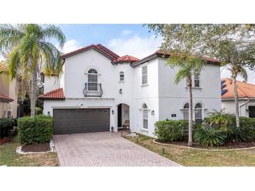 Two-story house with white walls, brown garage door, and a red tile roof at 11410 Rapallo Ln, Windermere, FL 34786