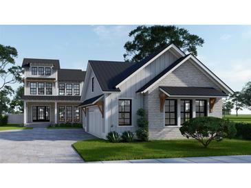 Two-story farmhouse style home with gray siding, black roof, and attached garage at 1258 Ridge Lake Way, Oakland, FL 34787
