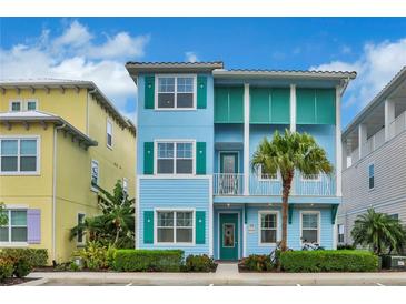 Two-story light blue house with teal accents, a balcony, and palm trees at 3056 Parrot Head Pl, Kissimmee, FL 34747