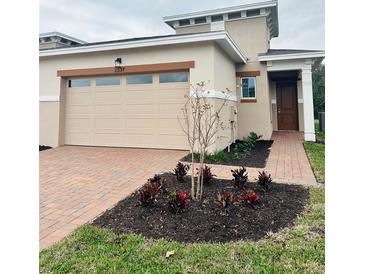 Tan two-story house with a two-car garage and landscaped front yard at 2337 Datura Loop, St Cloud, FL 34772