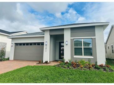 Modern one-story home with attached garage and landscaped front yard at 2817 Willowseed Ln, St Cloud, FL 34772