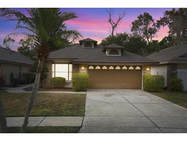 Charming single-story home at dusk with attached garage and landscaping at 314 Macgregor Rd, Winter Springs, FL 32708