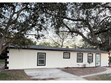 Charming single-story home with white exterior, black trim, and landscaping at 2449 Sunset Dr, Lake Wales, FL 33898