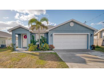 Charming light blue home with white trim, attached garage, and landscaped yard at 316 Bennett St, Auburndale, FL 33823