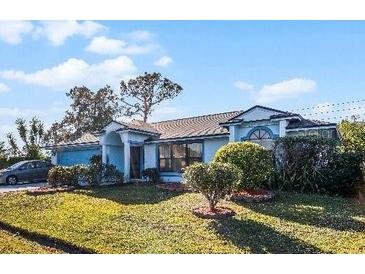 Single-story house with blue accents, a two-car garage, and a well-manicured lawn at 532 Maricopa Dr, Kissimmee, FL 34758