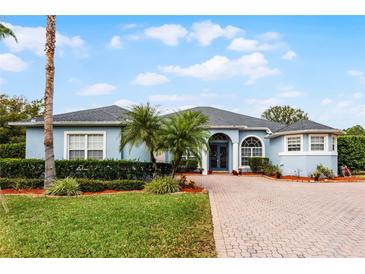 Beautiful one-story home with a paver driveway and lush landscaping at 5001 Whitewater Way, Saint Cloud, FL 34771