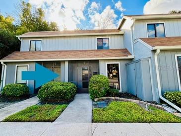 Two-story condo with brown roof and gray siding, featuring a walkway and landscaping at 10 Moree Loop # 13, Winter Springs, FL 32708