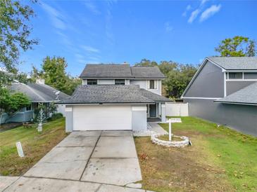 Two-story house with gray siding, attached garage, and landscaped yard at 3692 Okeechobee Cir, Casselberry, FL 32707