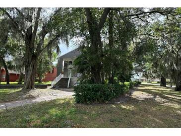 Two-story house with gray siding, stairs, and landscaping at 8322 Lake Lucy Dr, Orlando, FL 32818