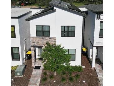 Modern two-story home with solar panels and stone accents at 212 Villa Domani Cir, Davenport, FL 33896