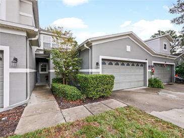 Attractive exterior of townhome with two-car garage and landscaped walkway at 1542 Travertine Ter, Sanford, FL 32771