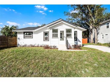 Charming bungalow with a renovated exterior, featuring a white facade and landscaped lawn at 1441 Dann St, Orlando, FL 32804