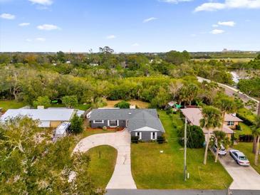 Aerial view of a single-Gathering home with a large yard and circular driveway at 2533 Edgewater Ave, New Smyrna Beach, FL 32168