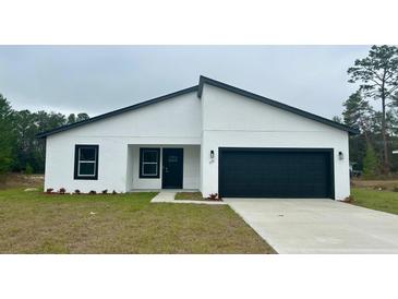 Modern single story home with white exterior and black garage door at 559 Marion Oaks Blvd, Ocala, FL 34473