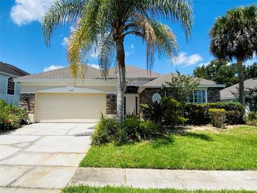 House exterior featuring stone accents and a lush lawn at 1748 Golfview Dr, Kissimmee, FL 34746